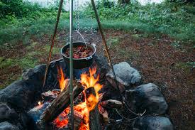 chili over a fire in the woods in a dutch oven